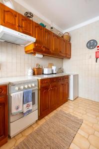 een keuken met houten kasten en een kookplaat met oven bij Casa das Andorinhas in Ferragudo