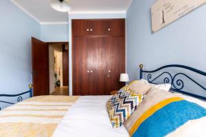 een slaapkamer met een bed en een houten kast bij Casa das Andorinhas in Ferragudo +5 foto's
