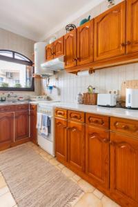 een keuken met houten kasten en een kookplaat met oven bij Casa das Andorinhas in Ferragudo