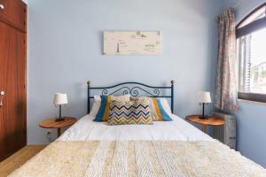 een slaapkamer met een bed met twee lampen op tafels bij Casa das Andorinhas in Ferragudo