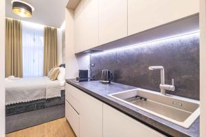 a kitchen with a sink and a bed in a room at ZAGABRIA - Modern Boutique Studios by Main Square in Zagreb