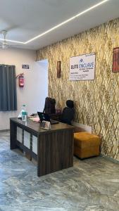 an office with a desk and a sign on a wall at Hotel Elite Enclave in Hyderabad