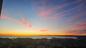 a view of a sunset over a city at Apartamento Faro Burela in Burela de Cabo