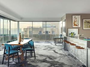 a room with a table and chairs and windows at The Olsen Melbourne Art Series in Melbourne