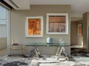 a glass table in a room with paintings and artwork at The Olsen Melbourne Art Series in Melbourne