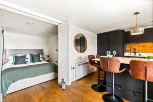 Un dormitorio con una cama y un escritorio y una cocina. en River Cabin With Mooing, en Remenham