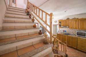 a spiral staircase in a kitchen with a counter at Guest Host - La Dimora degli Dei in Piras +26 photos