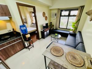 a living room with a couch and a table at Azalea 1BR Suite - Pool, Gym, WiFi, Netflix, AC, Kitchen, Ayala Mall in Cebu City
