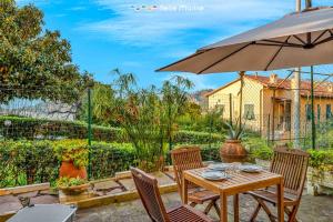 a patio with a table and chairs and an umbrella at Twilight, Terre Marine in Lerici