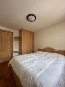 a bedroom with a large white bed and wooden cabinets at Chalet del Borgo in Le Bratte +14 photos