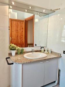 a bathroom with a sink and a mirror at Villetta a pochi passi dal mare in Àrbatax