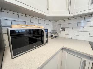 un microondas sentado en una encimera en una cocina en Merton Place, Southsea apartment with parking, en Southsea 18 fotos más
