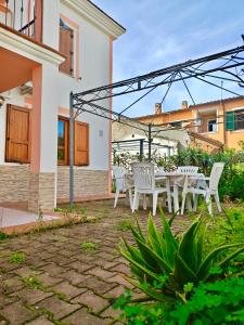 a patio with white chairs and a table at Villetta a pochi passi dal mare in Àrbatax