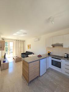 eine offene Küche und ein Wohnzimmer mit einem Sofa in der Unterkunft Aphrodite Hills Adonis Apartment in Kouklia