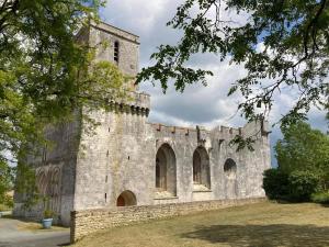 an old stone building with a tower at L Escale Esnandaise in Esnandes