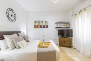 biała sypialnia z dużym łóżkiem i telewizorem w obiekcie Living4Malaga The Secret Studio w Maladze