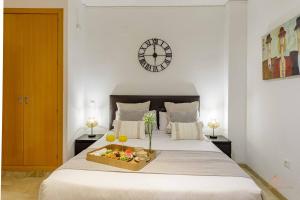 sypialnia z łóżkiem i tacą z owocami w obiekcie Living4Malaga The Secret Studio w Maladze