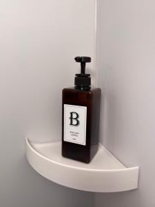 a bottle of soap sitting on a shelf at 最大8人利用完全貸切 広々テラス露天風呂付 ポーラ美術館徒歩5分 in Hakone