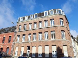 a tall red brick building with white windows at C5 Charmant petit deux pièces Centre ville in Cambrai