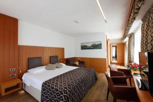 pokój hotelowy z łóżkiem i telewizorem w obiekcie Hotel Alaska Cortina w mieście Cortina dʼAmpezzo +37 zdjęć