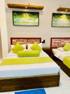- 2 lits avec des oreillers jaunes dans une chambre dans l'établissement Thinaya Lake Resort, à Anurâdhapura 70 autres photos
