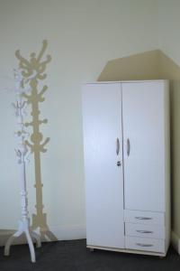 a white cabinet with a tree stenciled on the wall at غرفة مثالية في قلب القاهرة in Cairo