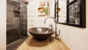 a bathroom with a bowl sink on a wooden counter at Kuschel Alpin Apartment & Traumblick Nockberge auf H1200m in Plessnitz
