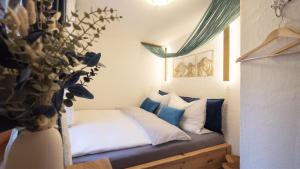a bedroom with a bed with blue and white pillows at Kuschel Alpin Apartment & Traumblick Nockberge auf H1200m in Plessnitz