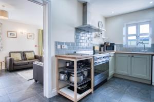 a kitchen with a sink and a stove top oven at The Chaffhouse - 4 Bedroom - Llangenith in Llangennith