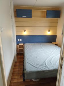 a small bedroom with a bed and two lights above it at Comme Chez Vous Au Camping Des Iscles in La Roque-dʼAnthéron +16 photos