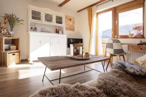 a living room with a table and a couch at Kuschel Alpin Apartment & Traumblick Nockberge auf H1200m in Plessnitz +33 photos