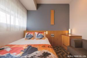 a small bedroom with a bed and a chair at Hotel Gracery Shinjuku in Tokyo