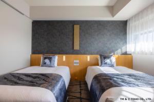 a bedroom with two beds and a window at Hotel Gracery Shinjuku in Tokyo