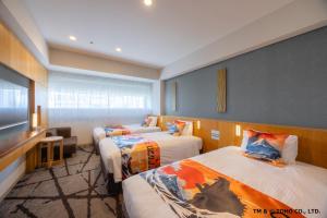 a hotel room with two beds and a television at Hotel Gracery Shinjuku in Tokyo