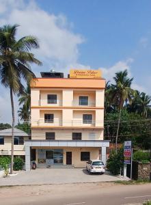 a building with a car parked in front of it at Royal Dream Palace International in Kovalam