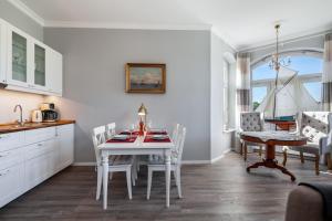 a kitchen and dining room with a white table and chairs at App Lolita in Kühlungsborn +20 photos