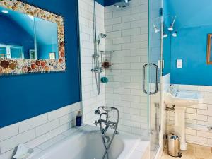 Baño azul con bañera y lavamanos en Exceptional retreat near Cornwall Coast, en Tywardreath 19 fotos más