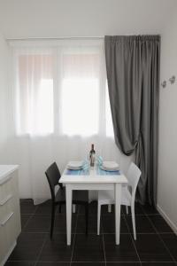 a white table and chairs in a kitchen with a window at Residence Città Ideale in Urbino