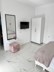 a white bedroom with a bed and a mirror at Villa Denis Ksamil in Ksamil