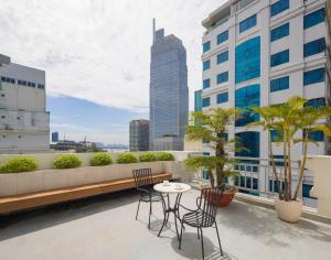 a balcony with chairs and a table on a building at White Lotus Hotel Saigon in Ho Chi Minh City