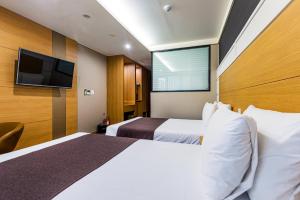 Postel nebo postele na pokoji v ubytování Eastern Hotel Jeju