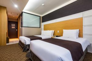 Postel nebo postele na pokoji v ubytování Eastern Hotel Jeju