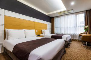 Postel nebo postele na pokoji v ubytování Eastern Hotel Jeju