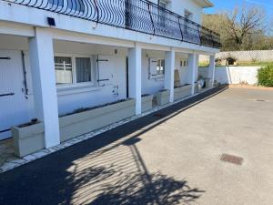 a white building with a balcony on the side at Mer campagne vignobles in Bretignolles-sur-Mer