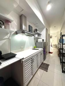 纳苏格布Beach condos at Pico de Loro Cove - Wi-Fi & Netflix, 42-50''TVs with Cignal cable, Uratex beds & pillows, equipped kitchen, balcony, parking - guest registration fee is not included的带水槽和台面的厨房