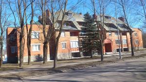 a large brick building on a street with trees at Near border in Narva