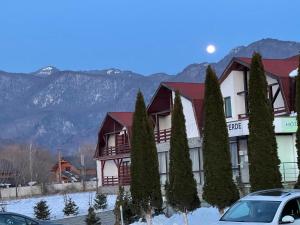 a hotel in the mountains with snow on the ground at Conca Verde Râșnov in Râşnov