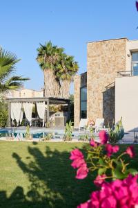 a house with a yard with pink flowers at Ocean Private Villas - Pefkochori Halkidiki in Pefkochori
