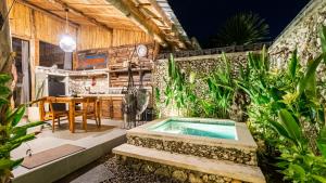 a patio with a jacuzzi tub in a garden at Alma Surf Villas 2 - Cozy 01 Bed with Private Pool in Uluwatu