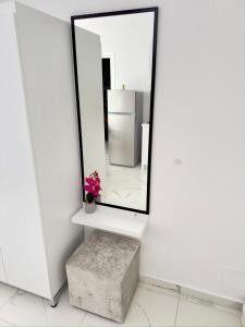 a mirror in a white room with a stool at Villa Denis Ksamil in Ksamil